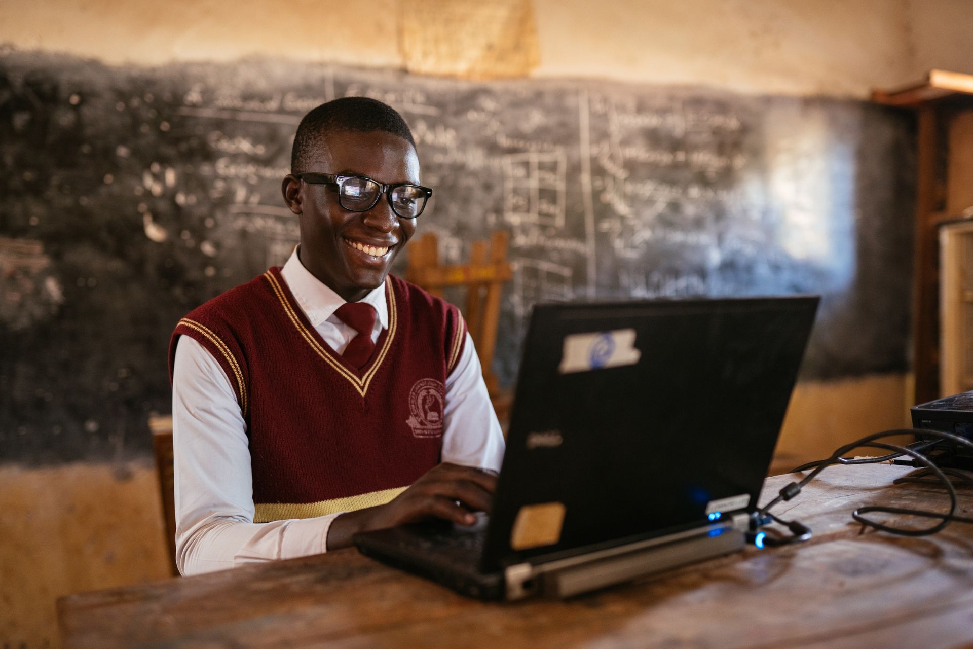 student in ghana typing at a desk