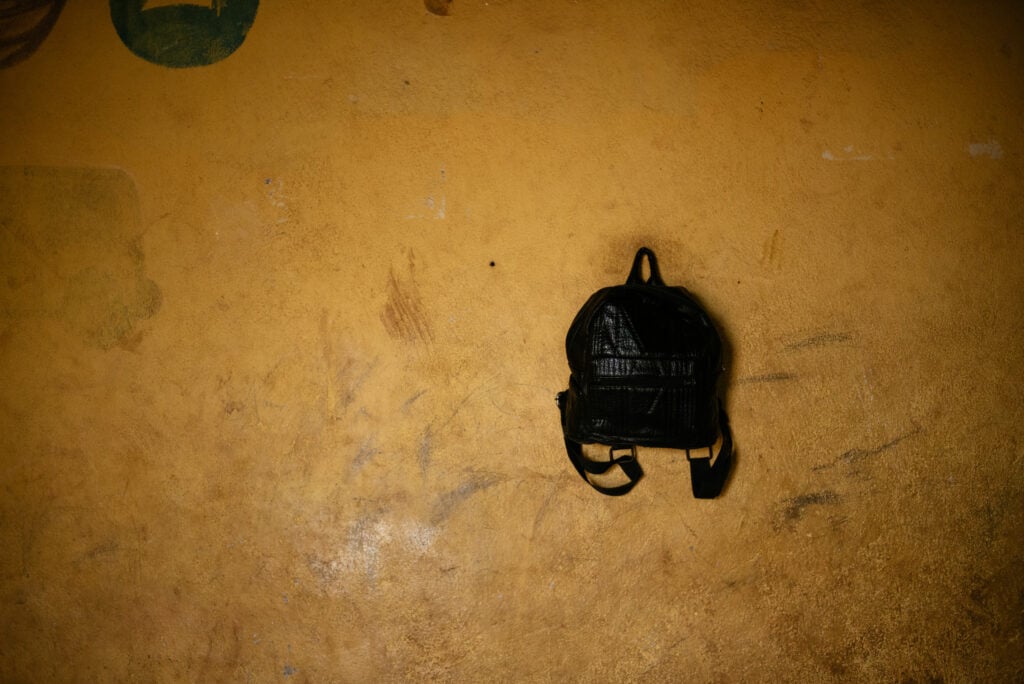 black backpack on school wall