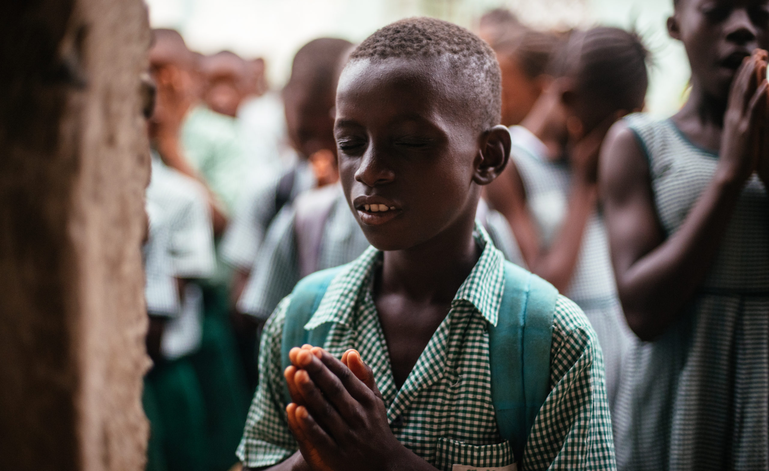 student in sierra leone praying