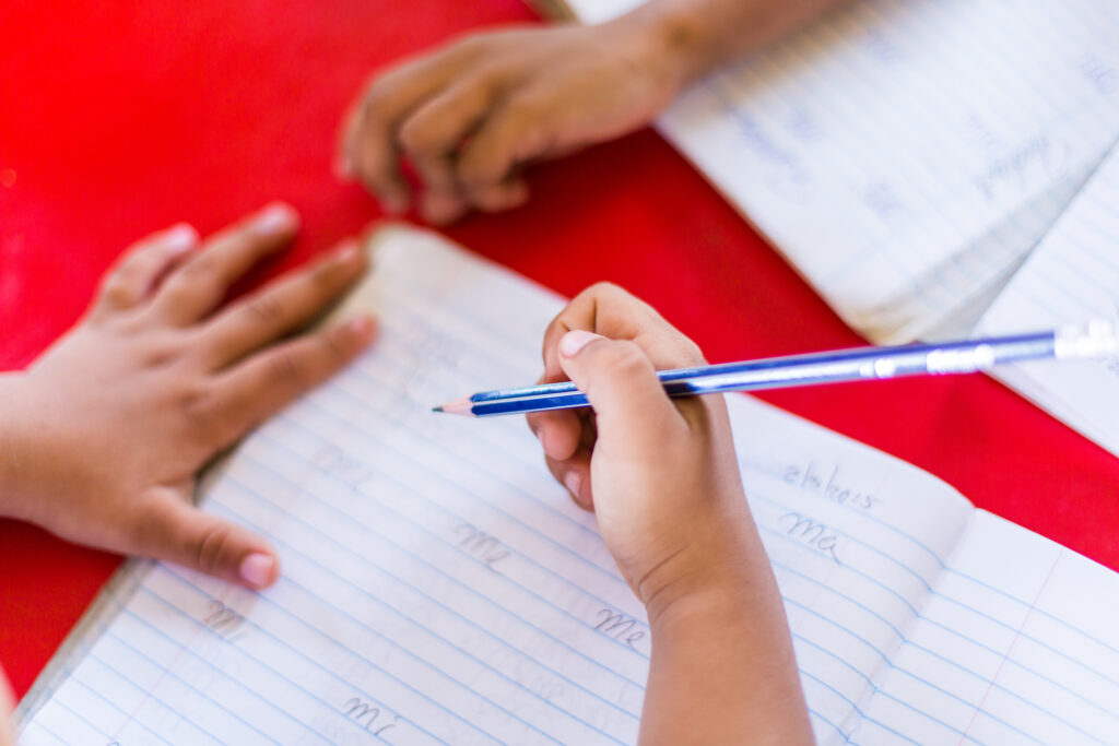 student hands writing on a piece of paper
