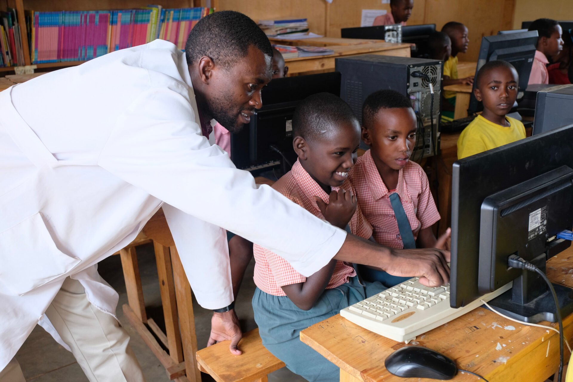 Students at computers with teacher learning in Africa