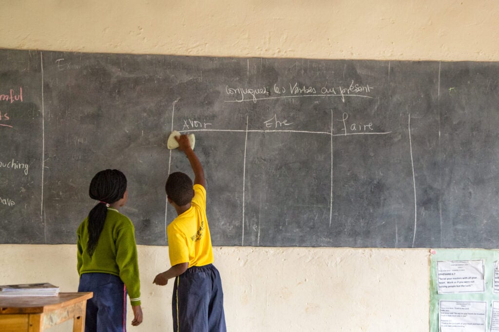students in Rwanda at a chalkboard in a classroom