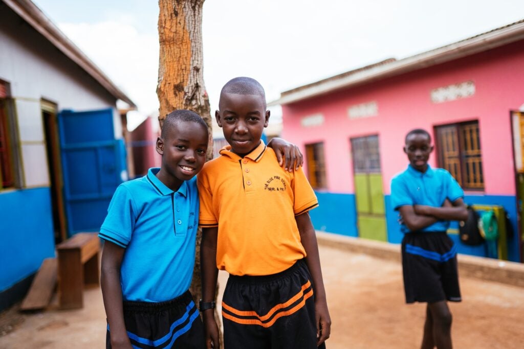 students in Uganda smiling together outside of school